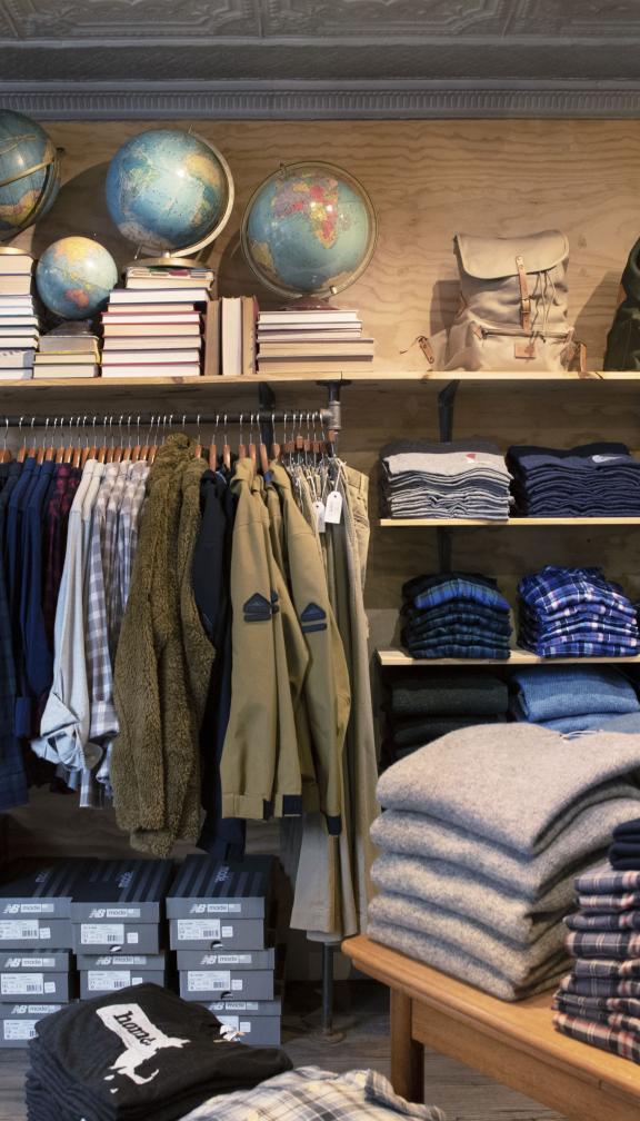 Inside a clothing shop in Boston featuring sweaters, shirts and backpacks
